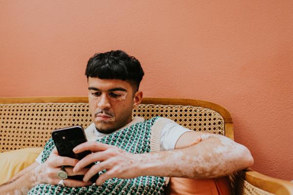 A man sitting on a chair using his phone